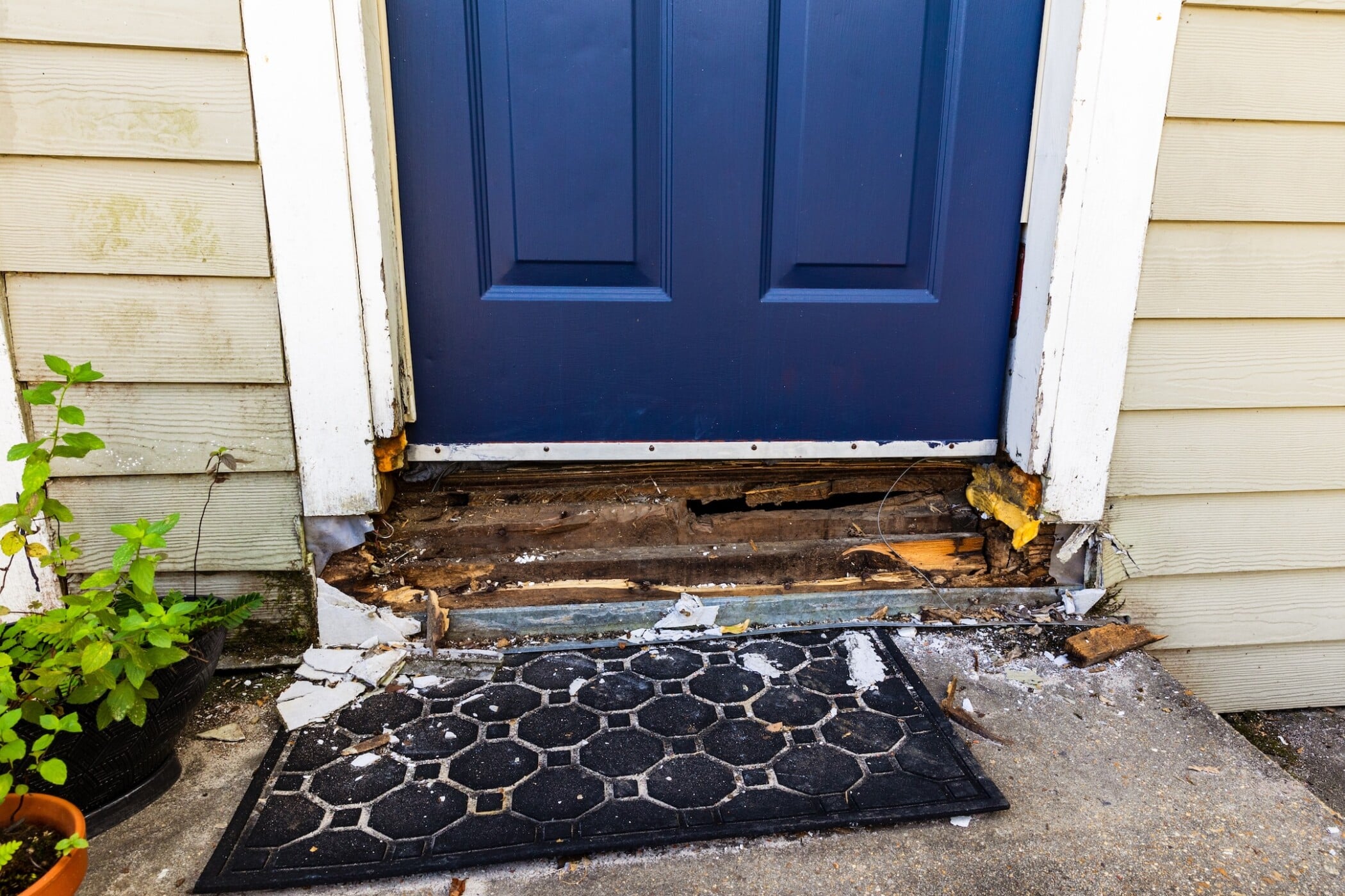 Damaged wood frame of door being repaired